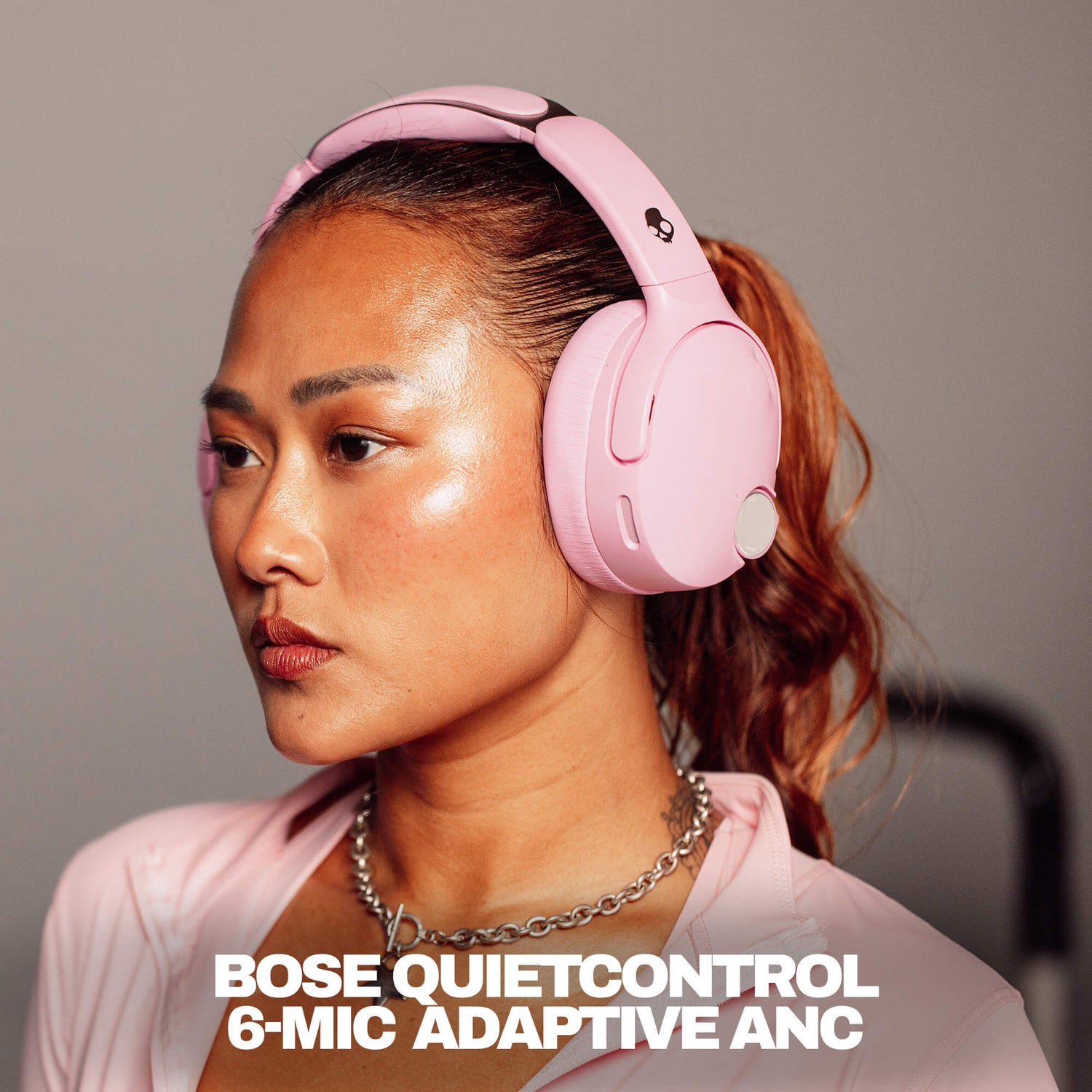 Woman wearing pink Skullcandy Crusher 1080 ANC with Bose QuietControl headphones with text overlay. | Candy