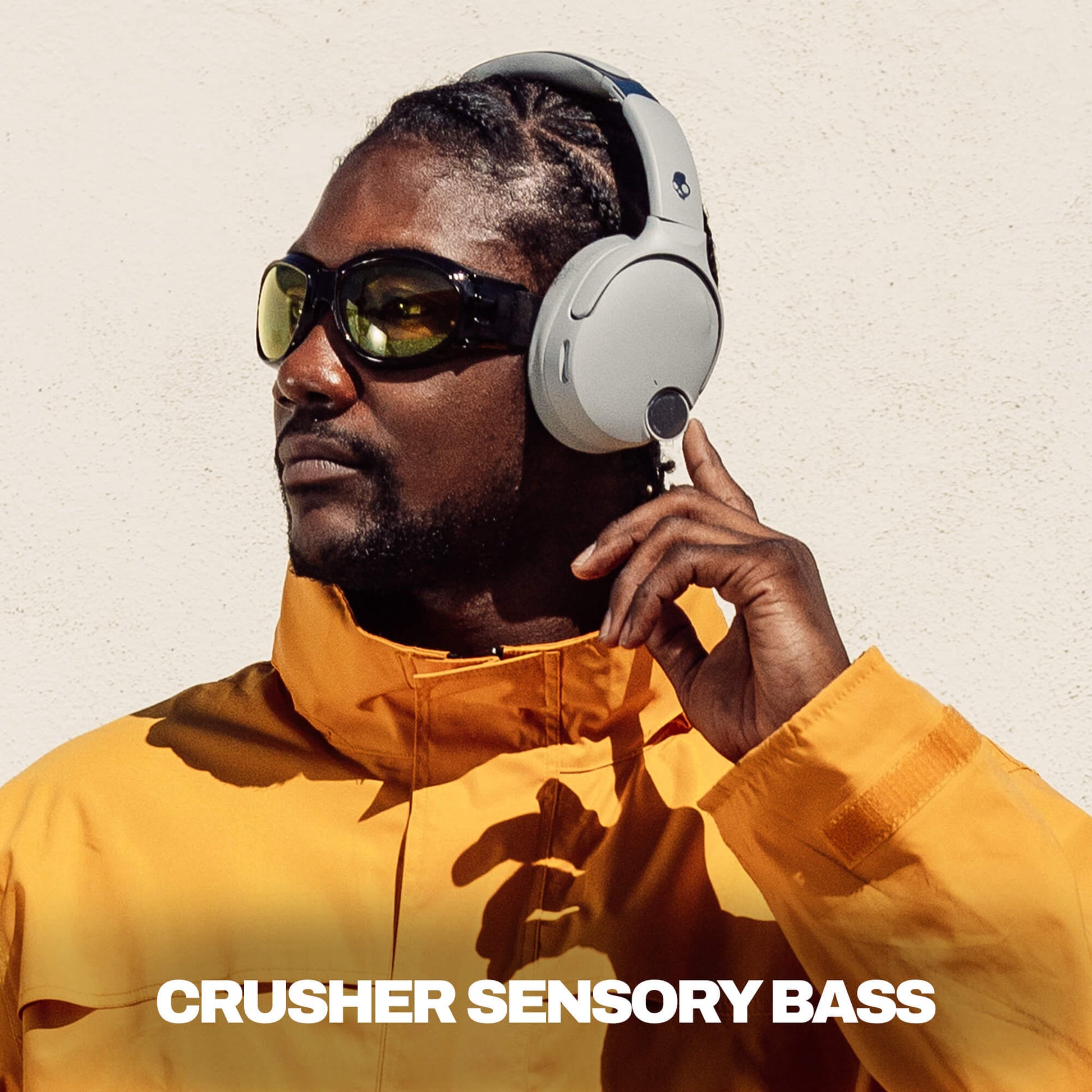 Man wearing Crusehr 1080 ANC headphones and sunglasses with a text overlay on a plain background | Cement