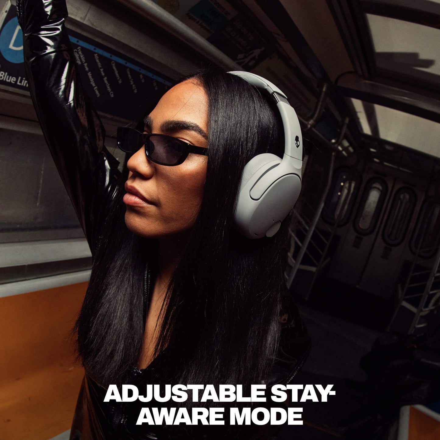 Person wearing Crusher 720 headphones and sunglasses inside a vehicle with text 'Adjustable Stay Aware Mode'. | Cement