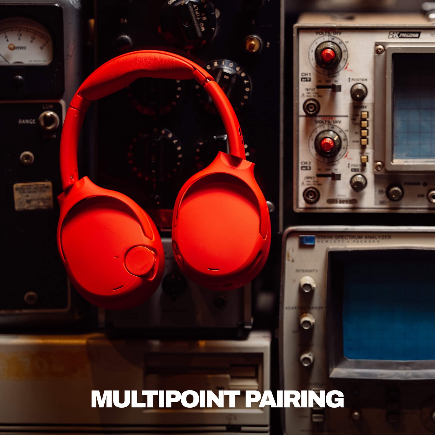 Red Crusher 720 headphones on a vintage electronic equipment background with 'MULTIPOINT PAIRING' text. | Plasma