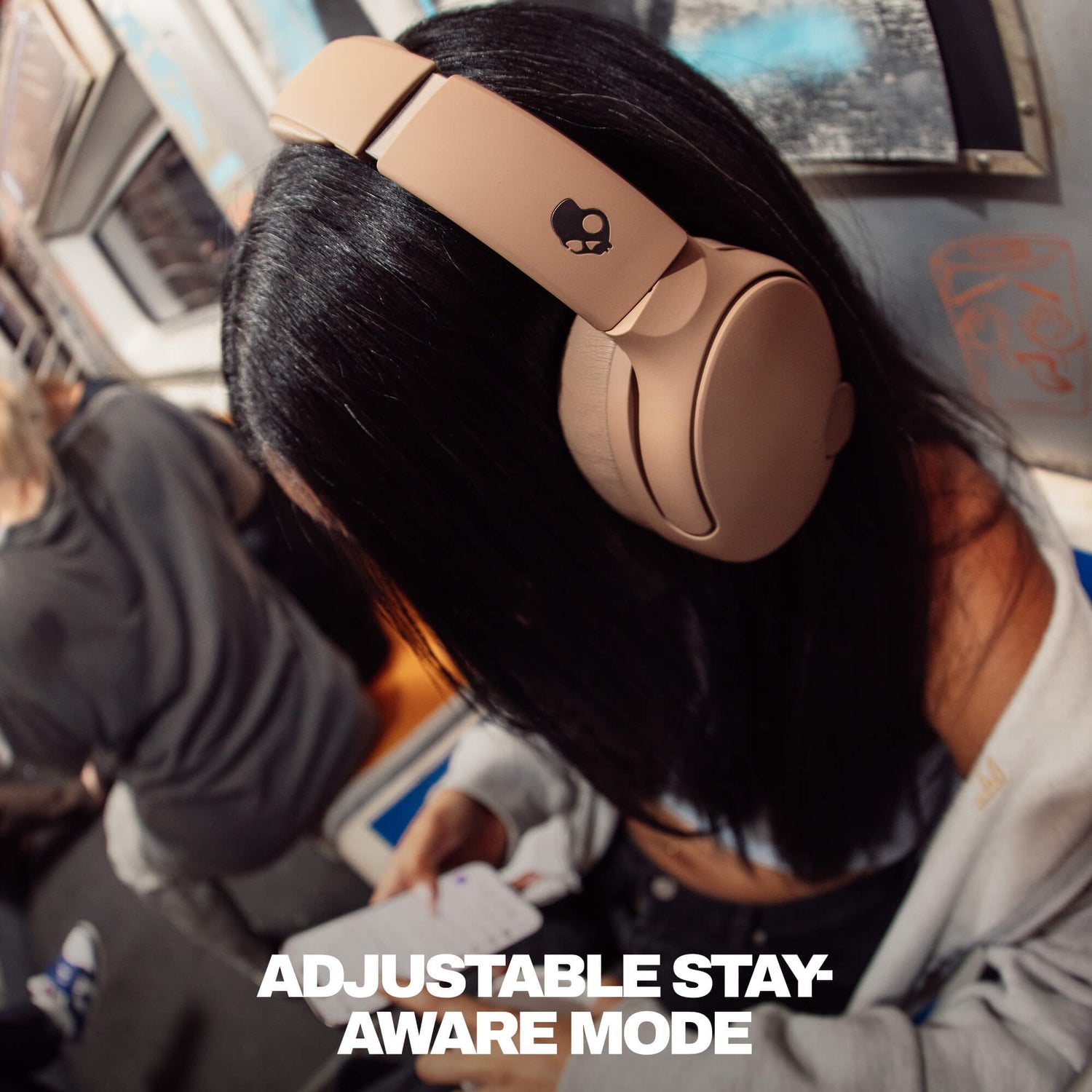 Person wearing brown Crusher 720 headphones on a plane with text 'Adjustable Stay Aware Mode'. | Primer