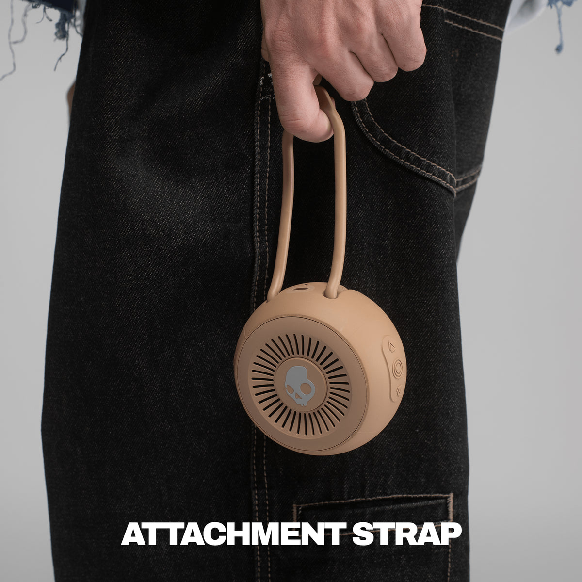 Primer attachment strap for speaker being held by someone with black pants | Primer
