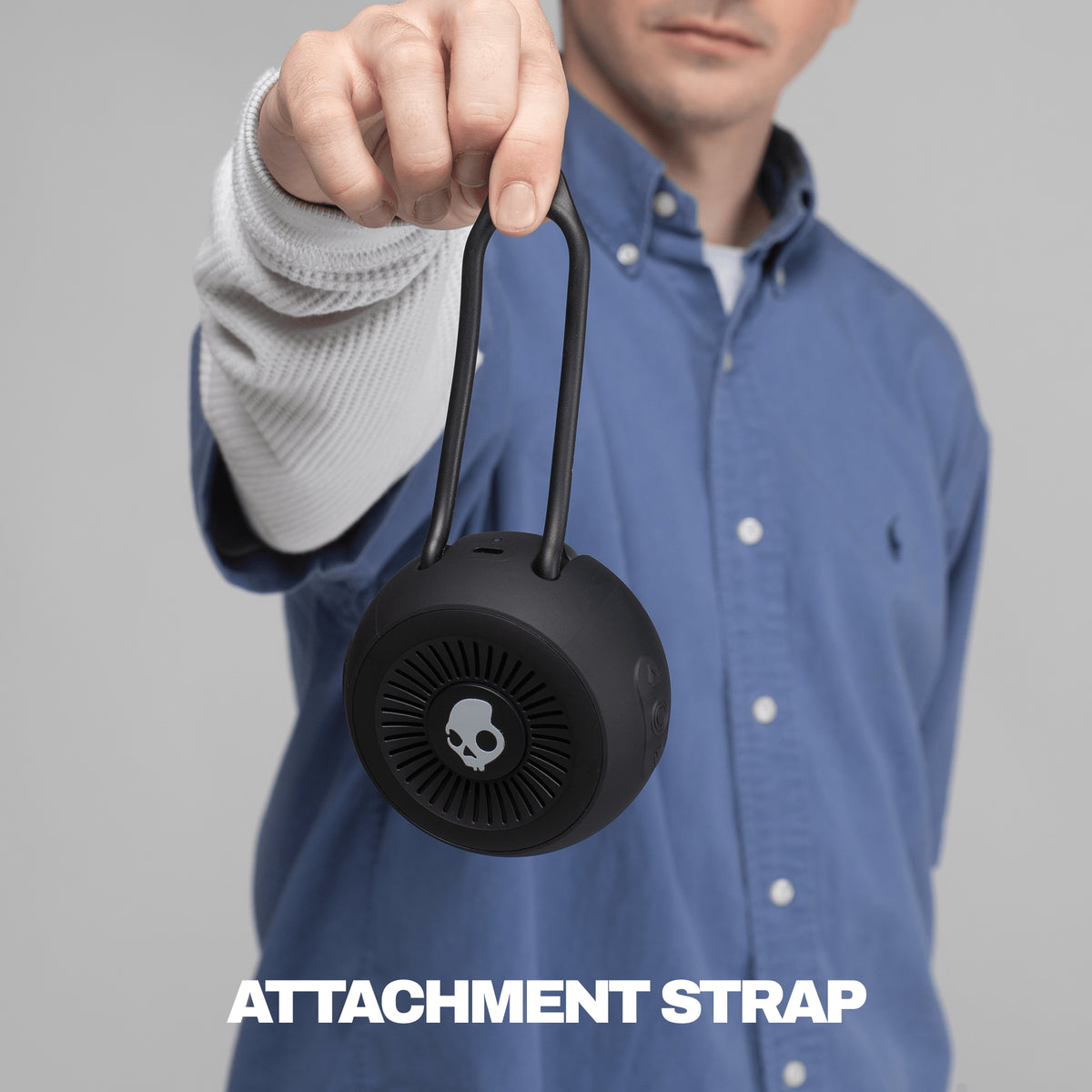 Black attachment strap for session 360 speaker being held by someone in a blue and white shirt | True Black