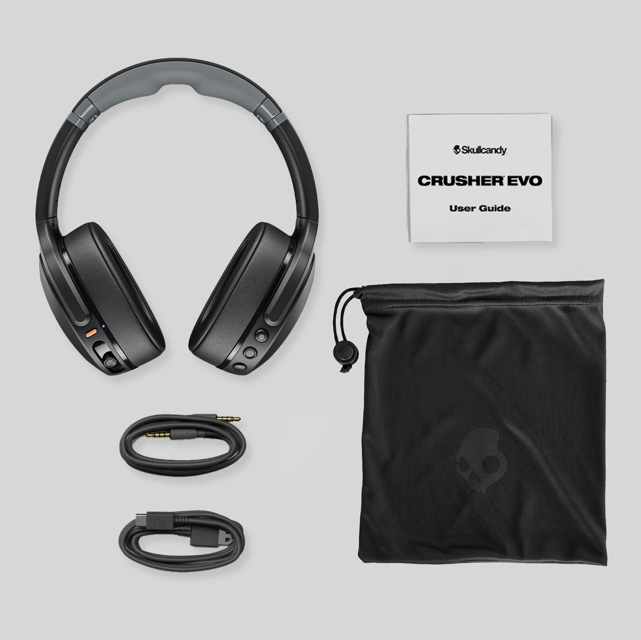 Skullcandy Crusher EVO headphones with user guide and carrying case on a light gray background | Dustbox