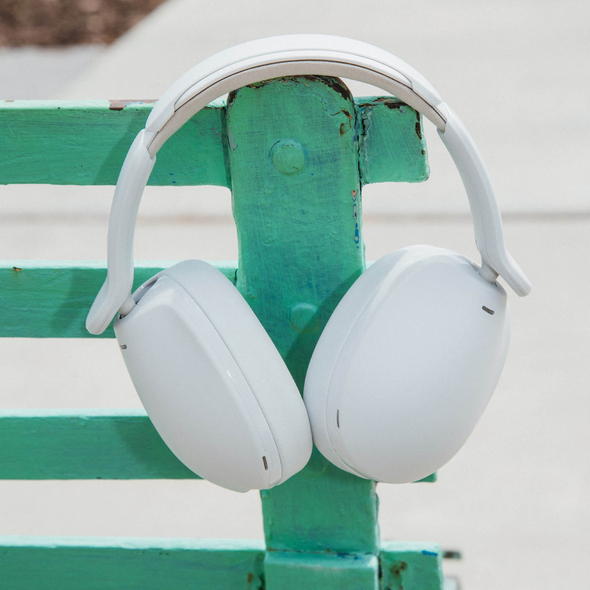 White hesh 360 headphones on a green and white striped bench | Bone