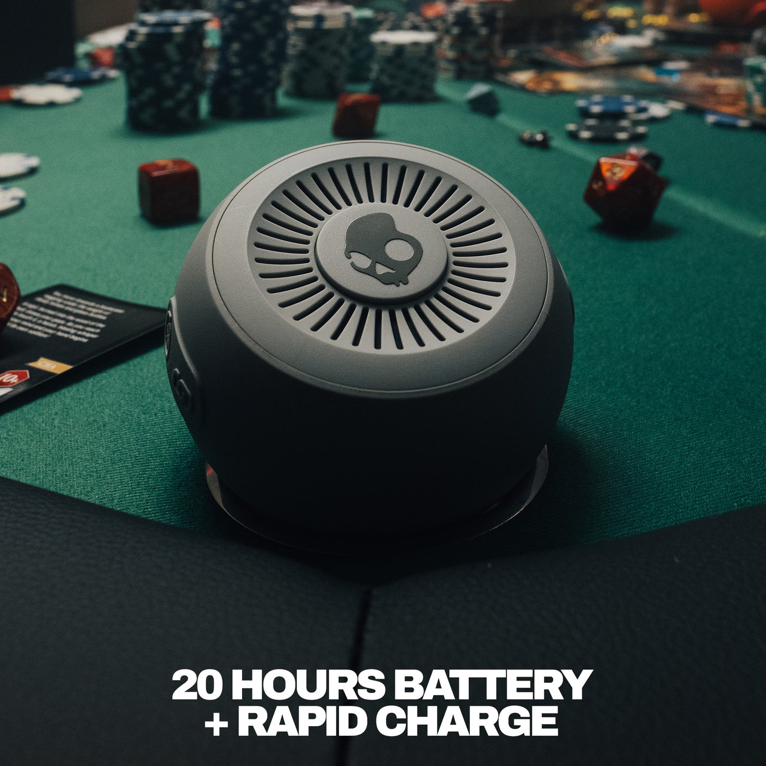 Round electronic device on a gaming table with text about battery life and charging. | Cement