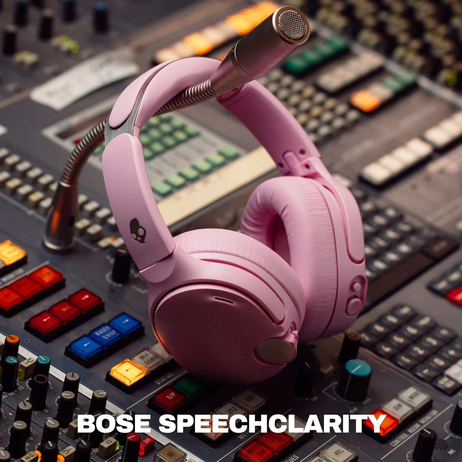 Pink Crusher 1080 over-ear headphones with a boom microphone resting on a professional audio mixing board. The text 'BOSE SPEECHCLARITY' is displayed at the bottom. | Candy